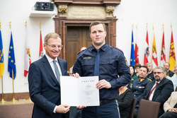 Landeshauptmann Mag. Thomas Stelzer verleiht die Dank- und Anerkennungsurkunde an Revierinspektor David Schmidsberger.