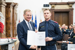 Landeshauptmann Mag. Thomas Stelzer verleiht die Dank- und Anerkennungsurkunde an Inspektor Tobias Kutzenberger.