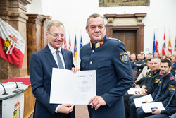 Landeshauptmann Mag. Thomas Stelzer verleiht die Dank- und Anerkennungsurkunde an Bezirksinspektor Erhard Steinmayer.