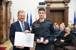 Landeshauptmann Mag. Thomas Stelzer verleiht die OÖ Lebensrettungsmedaille in Bronze an Bezirksinspektor Jakob Karlsböck.