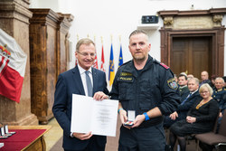 Landeshauptmann Mag. Thomas Stelzer verleiht die OÖ Lebensrettungsmedaille in Bronze an Revierinspektor Jürgen Ruckendorfer.